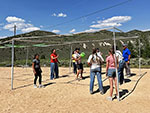 A group of people playing 9 Square in the Air on a sunny day.