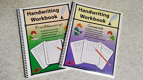 Print/Manuscript and Cursive Handwriting Workbooks sitting on a table.