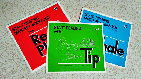 Two workbooks and a reader from the Start Reading series displayed on a table.